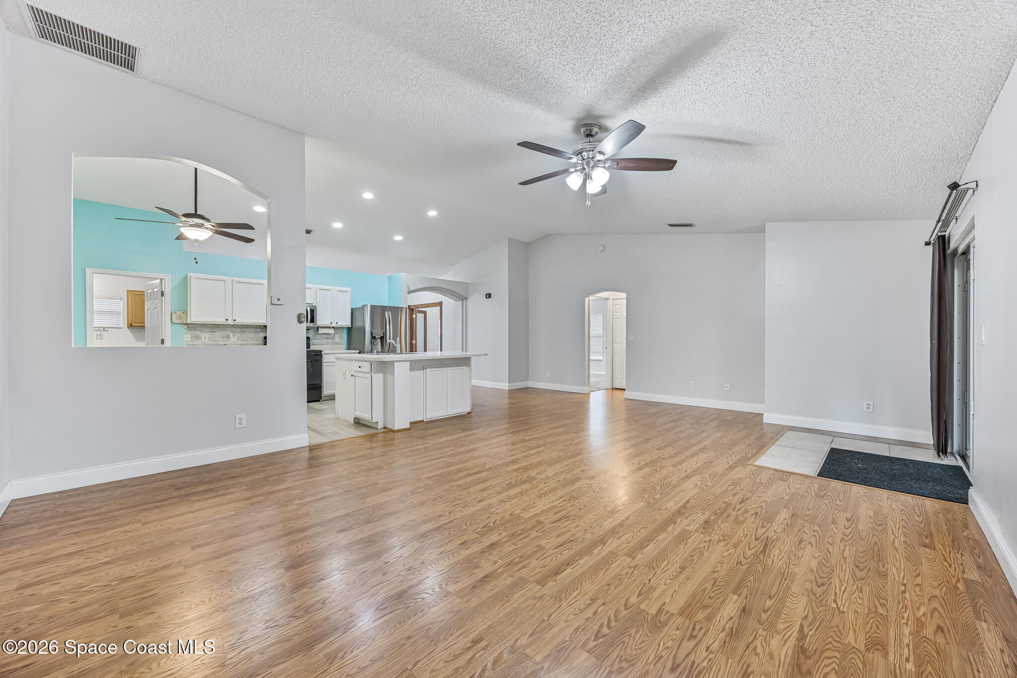 6185 Degan Road Cocoa, FL 32927 - Photo 13 of 30 a view of a livingroom with a hardwood floor and a ceiling fan