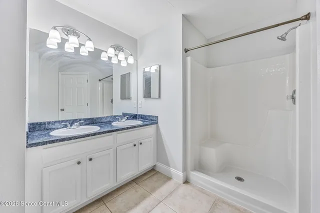 a bathroom with a granite countertop sink a toilet a mirror and shower