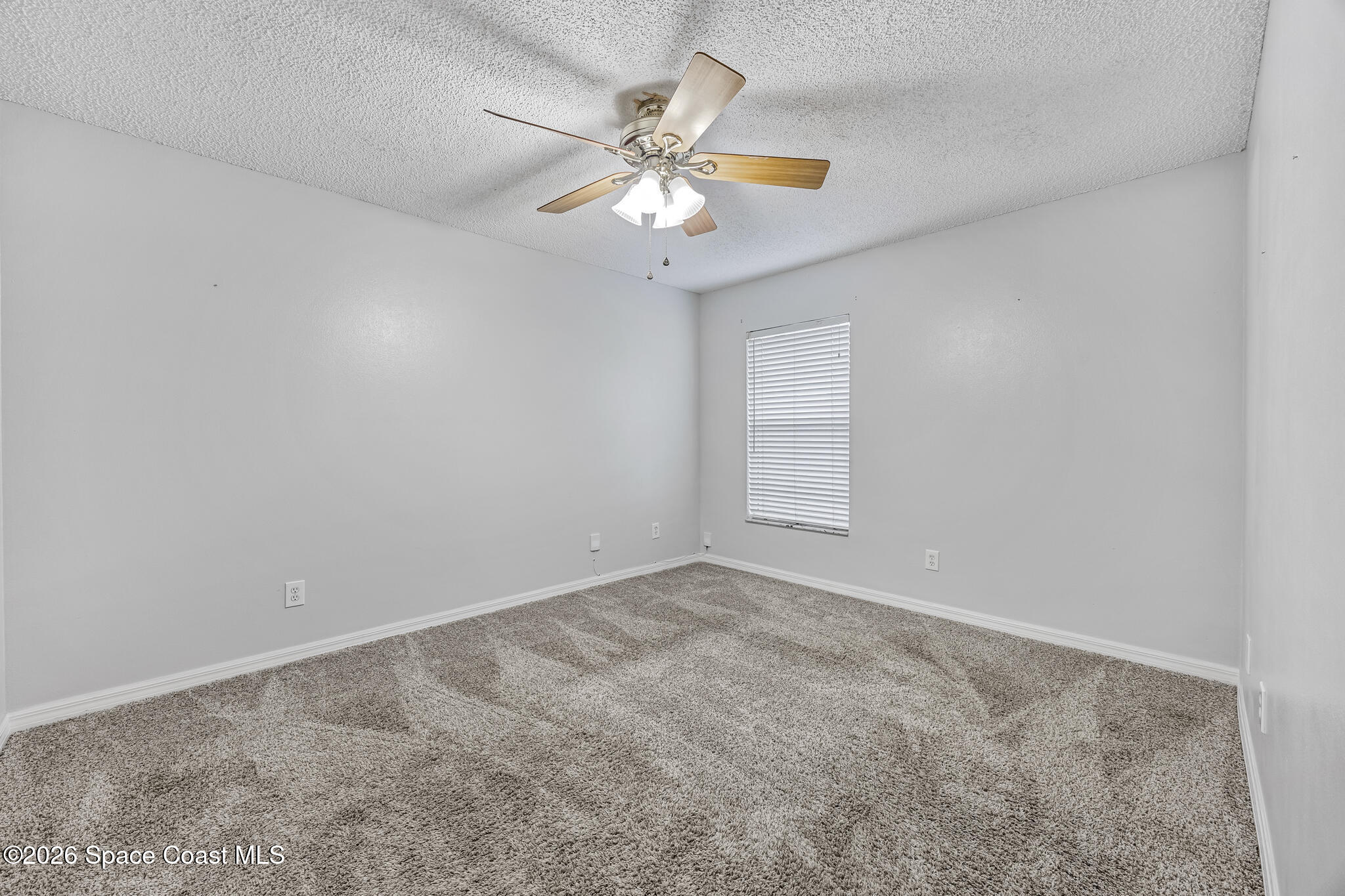 6185 Degan Road Cocoa, FL 32927 - Photo 21 of 30 an empty room with windows and fan