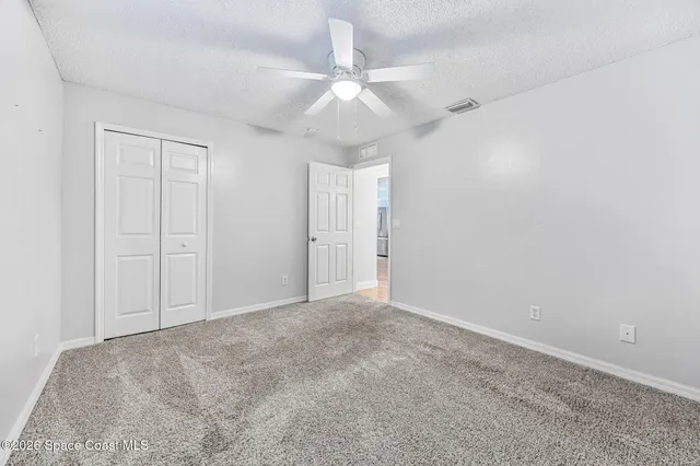an empty room with a window and a ceiling fan