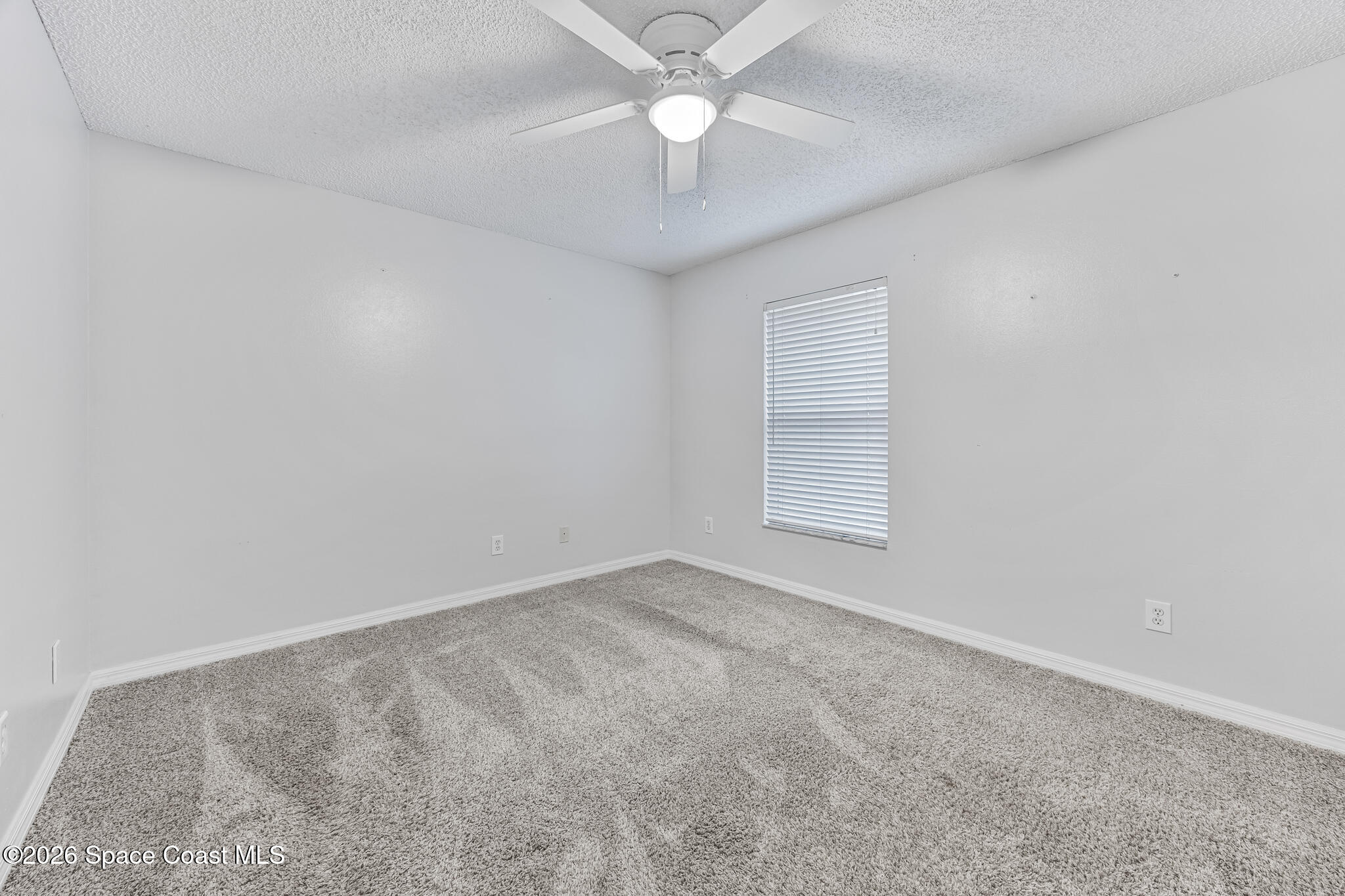 6185 Degan Road Cocoa, FL 32927 - Photo 24 of 30 an empty room with a window and a ceiling fan