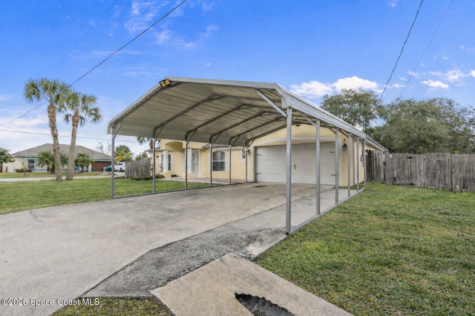 6185 Degan Road Cocoa, FL 32927 - Photo 3 of 30 a yellow house with a yard and wooden fence