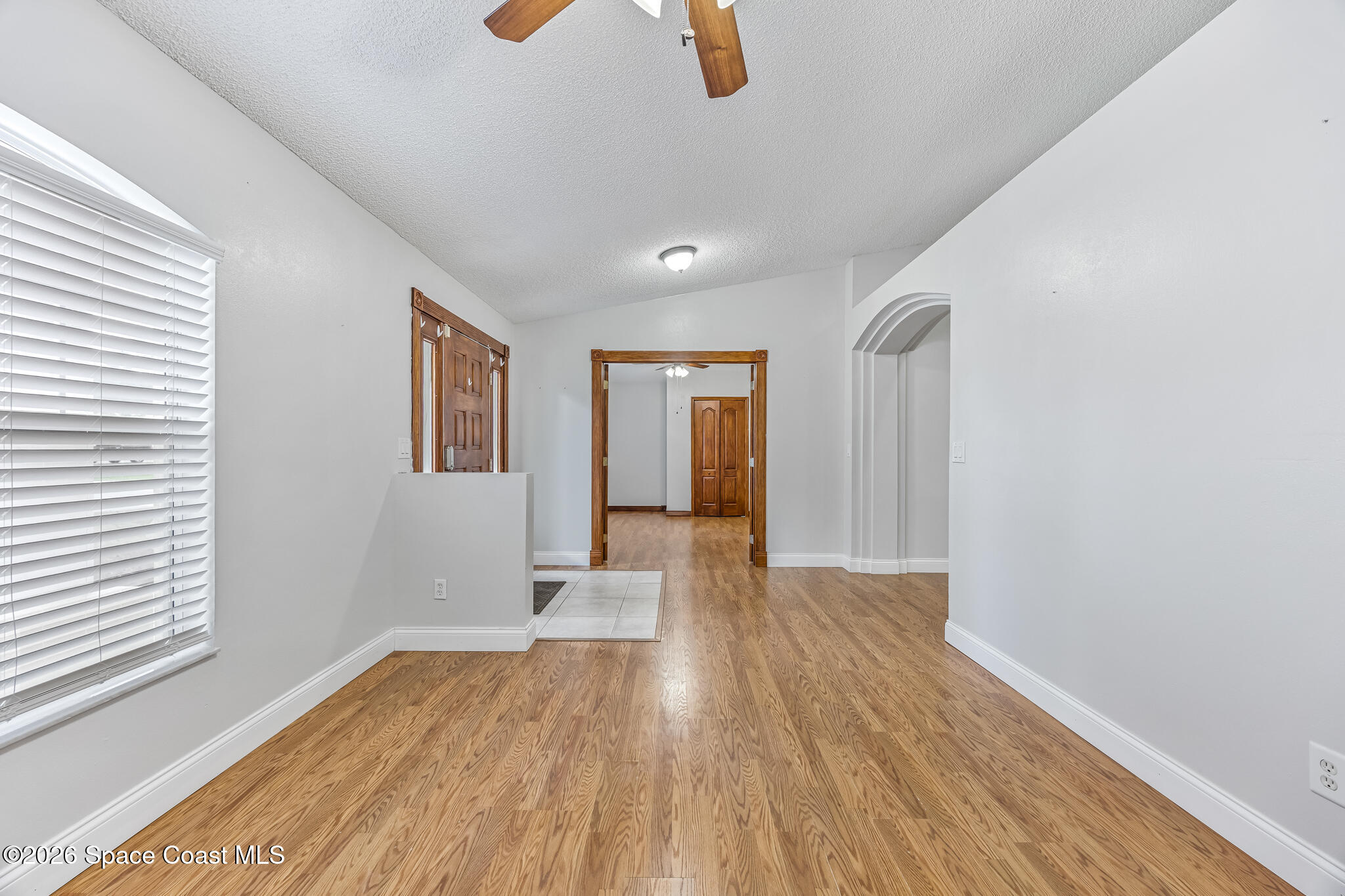 6185 Degan Road Cocoa, FL 32927 - Photo 5 of 30 a view of an empty room with wooden floor and a window