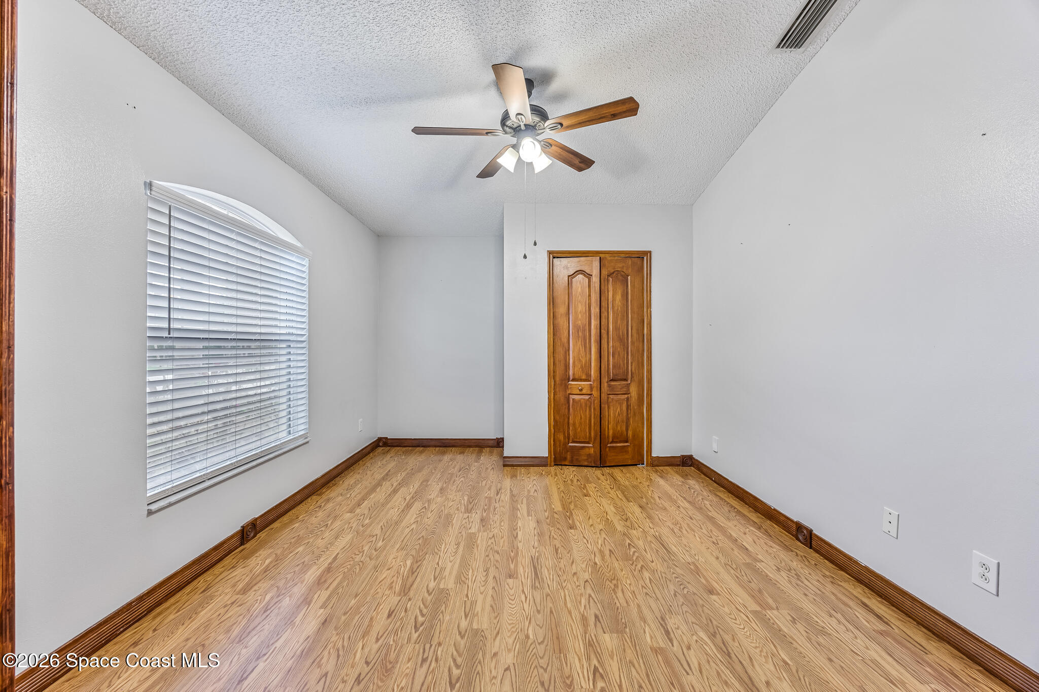 6185 Degan Road Cocoa, FL 32927 - Photo 8 of 30 a view of an empty room with wooden floor and a window