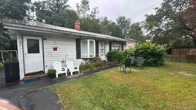 a view of a house with backyard and sitting area