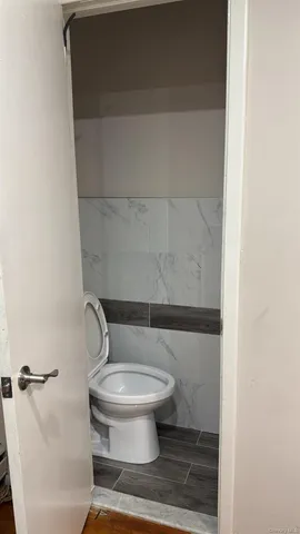 a white toilet sitting next to a shower