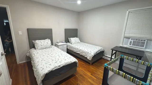 a bedroom with two beds and wooden floor