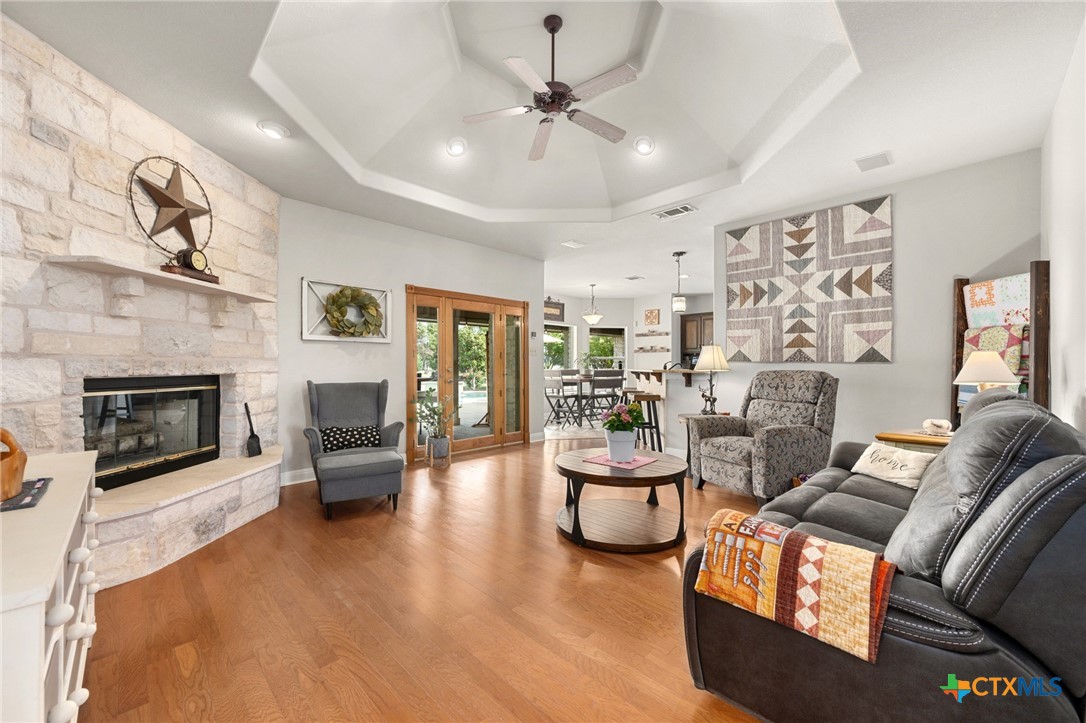 106 Starlight Trail Georgetown, TX 78633 - Photo 12 of 47 Stone Fireplace - Wood Flooring - Coffered Ceiling - Open to Kitchen and Breakfast Room