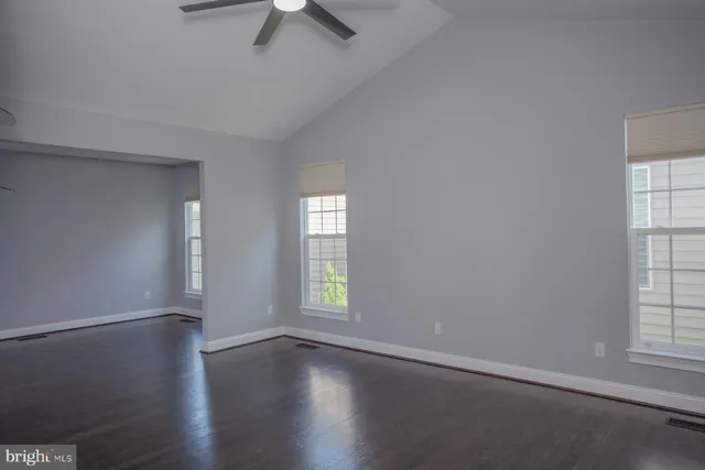a view of empty room with wooden floor and fireplace