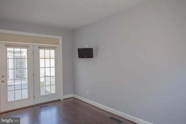 a view of a livingroom with wooden floor and a ceiling fan