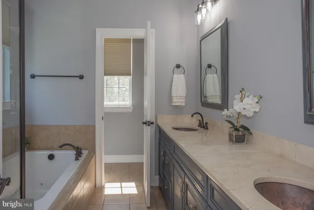 a bathroom with double vanity sinks and a mirror