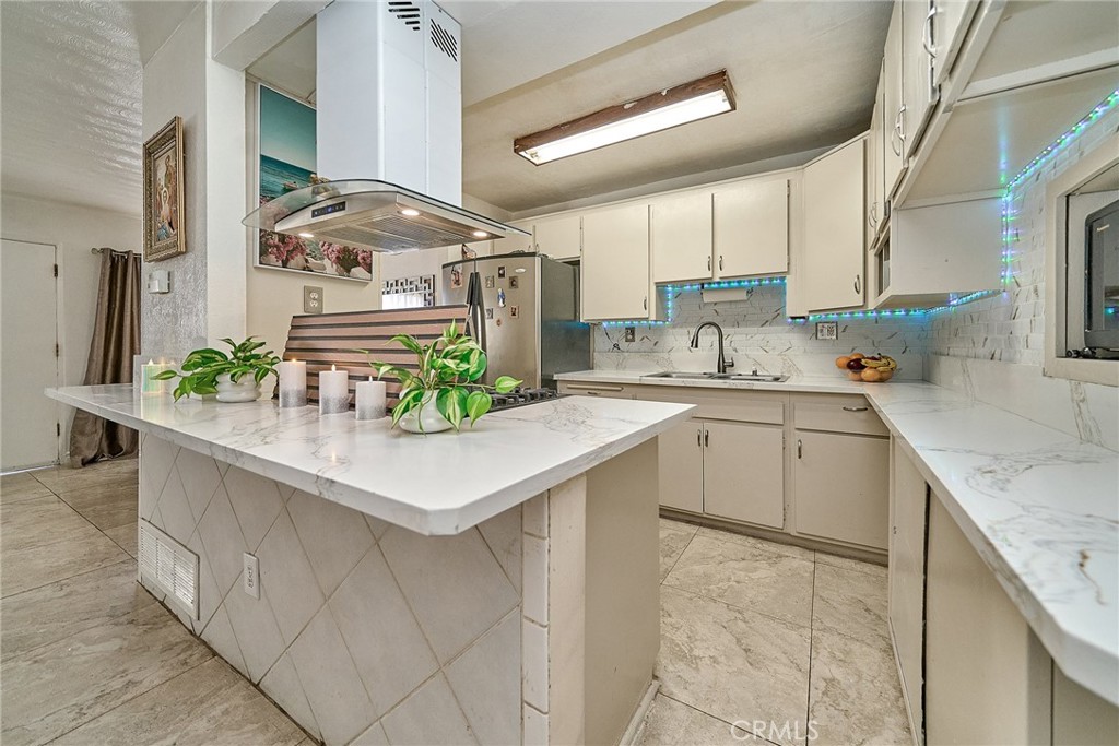 a kitchen with stainless steel appliances granite countertop a sink a stove and a wooden floors