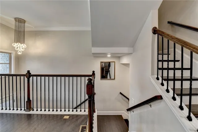 a view of staircase with railing and a chandelier