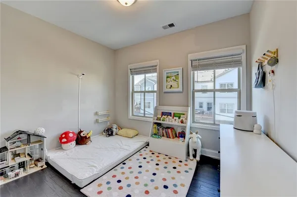 an empty room with wooden floor and windows