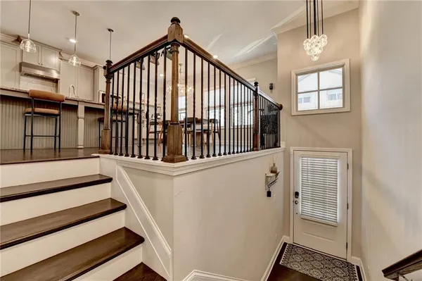 a large kitchen with cabinets chairs and wooden floor