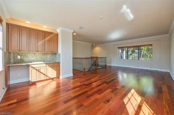 a view of empty room with kitchen and window