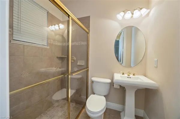 a bathroom with a sink mirror toilet and a shower