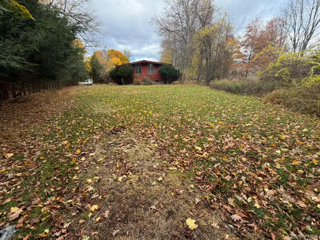 a backyard of a house with trees and outdoor seating