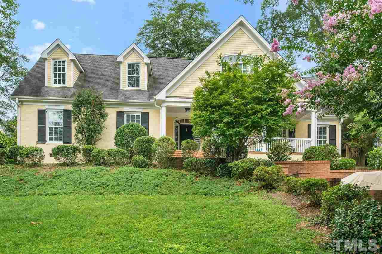 a front view of a house with a yard and trees