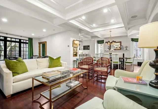 a living room with furniture kitchen view and a wooden floor