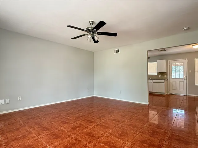 a view of empty room with wooden floor and window
