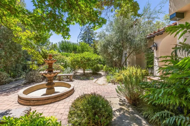 a view of an empty room with wooden floor fireplace and a window