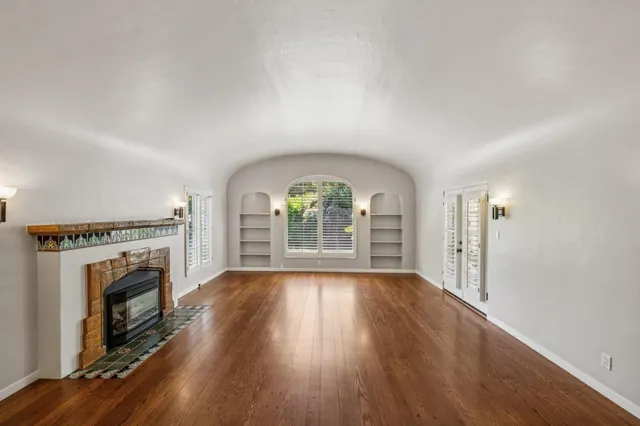 an empty room with wooden floor and fireplace