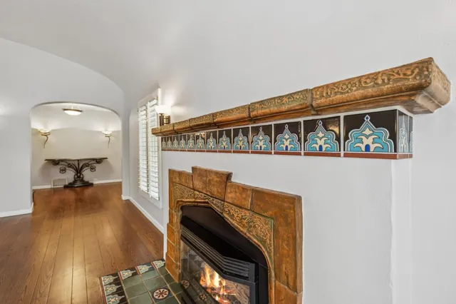 a view of empty room with wooden floor and fireplace