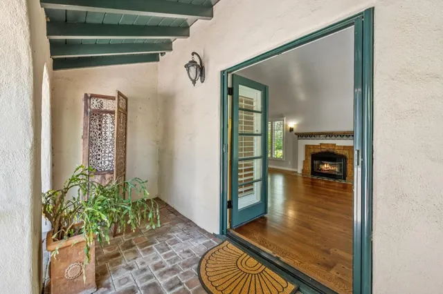 a view of a hallway with wooden floor and a bathroom