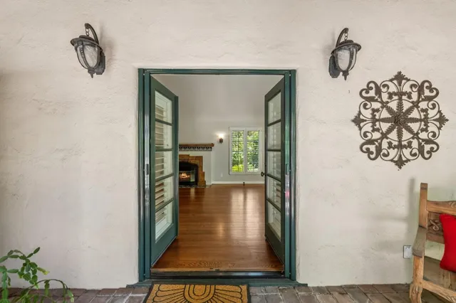 a view of an empty room with glass door and wooden floor