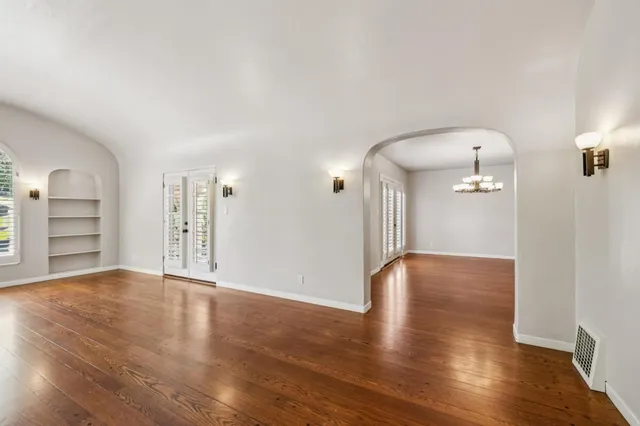 a view of a yard with plants and large trees