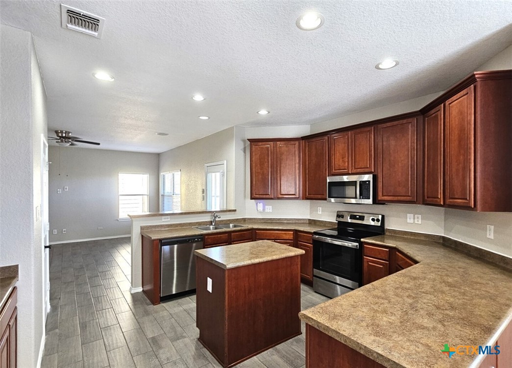 316 Julian Point Cibolo, TX 78108 - Photo 3 of 28 a kitchen with stainless steel appliances granite countertop wooden cabinets a stove top oven a sink and dishwasher