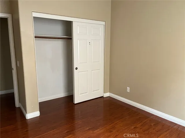 an empty room with wooden floor and closet