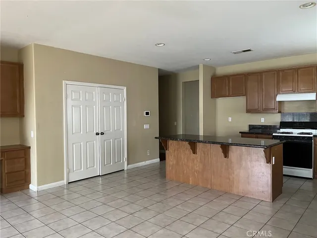 a kitchen with granite countertop white cabinets and stainless steel appliances