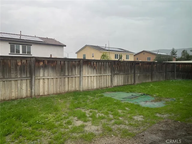 a view of a yard with wooden fence