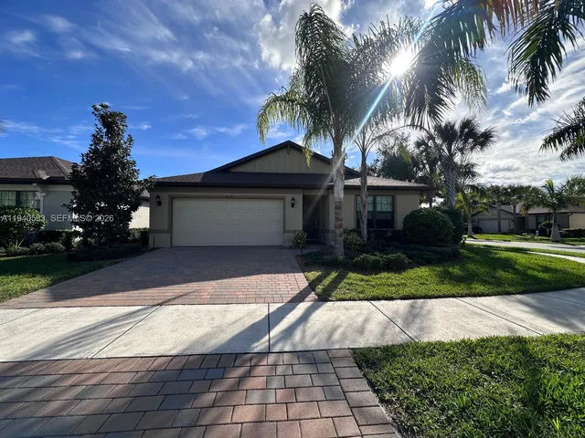 a front view of a house with a yard and potted plants