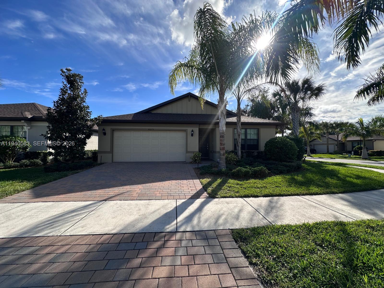 4675 Indigo Way, Unit 4675 Vero Beach, FL 32967 - Photo 18 of 19 a front view of a house with a yard and potted plants