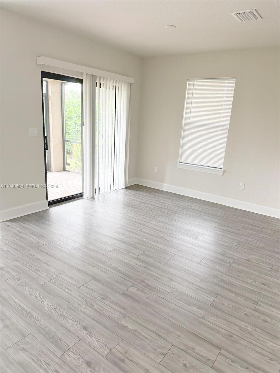 4675 Indigo Way, Unit 4675 Vero Beach, FL 32967 - Photo 6 of 19 an empty room with wooden floor and windows