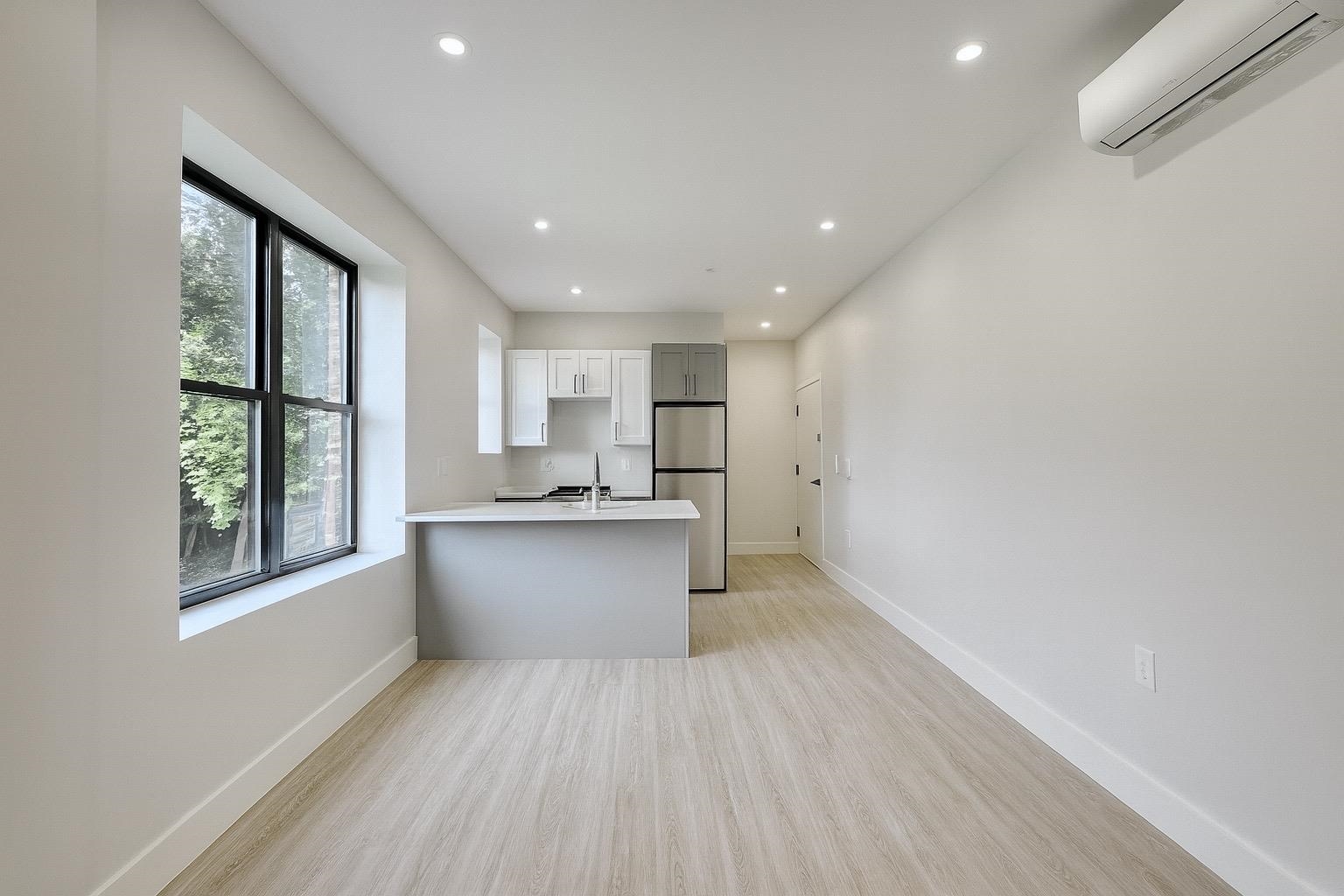 103 Bostwick Avenue, Unit 4B Jersey City, NJ 07305 - Photo 2 of 12 a view of kitchen with stainless steel appliances granite countertop a stove a sink and a large window