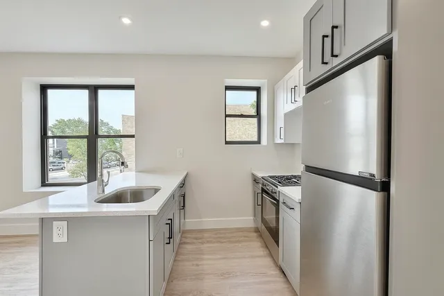 a kitchen with granite countertop a refrigerator and a sink