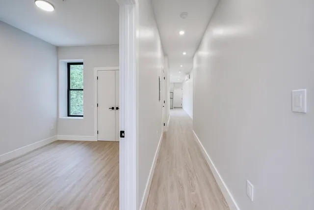 a view of a hallway with wooden floor