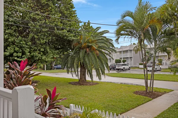 a kitchen with stainless steel appliances granite countertop a stove a sink dishwasher and a microwave oven with large trees