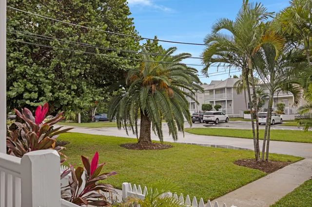 a kitchen with stainless steel appliances granite countertop a stove a sink dishwasher and a microwave oven with large trees