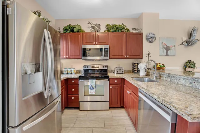 a kitchen with stainless steel appliances granite countertop a refrigerator stove and sink