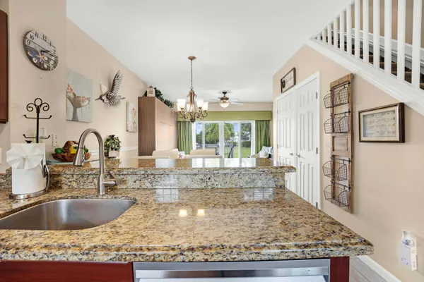 a kitchen with kitchen island granite countertop a sink and a window
