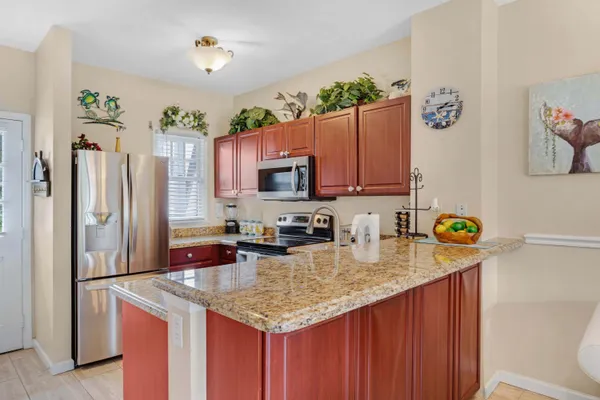 a kitchen with stainless steel appliances granite countertop a refrigerator a stove and a sink