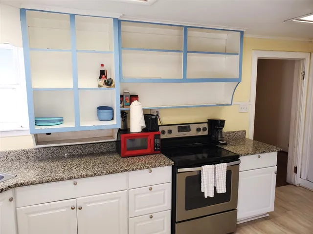 a kitchen with granite countertop a stove and a cabinet