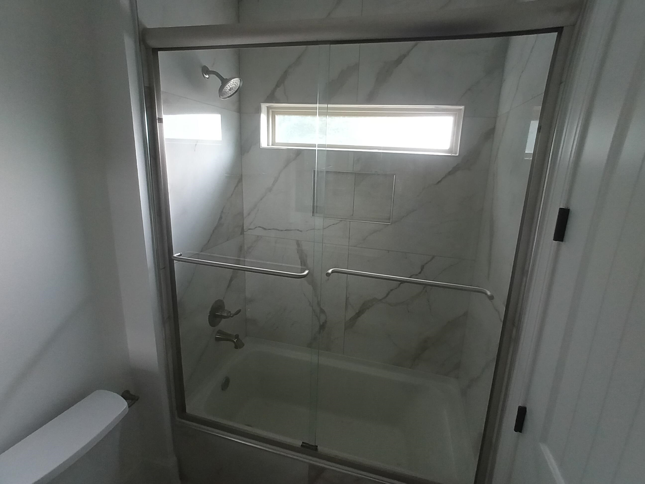 5690 Walnut Grove Road Memphis, TN 38120 - Photo 23 of 40 a bathroom with a glass shower door