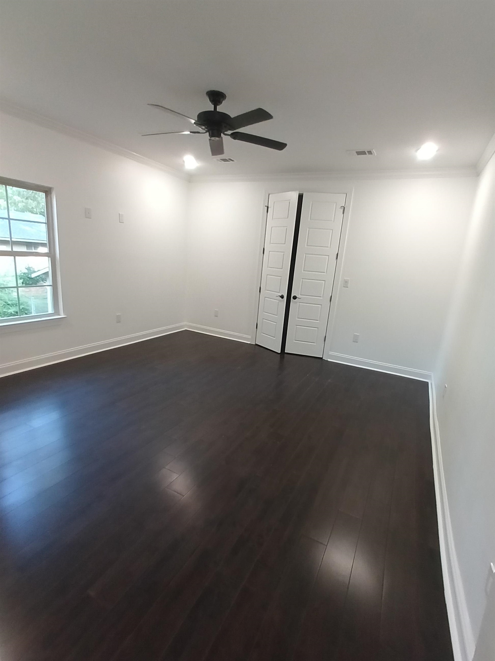 5690 Walnut Grove Road Memphis, TN 38120 - Photo 30 of 40 an empty room with wooden floor fan and windows
