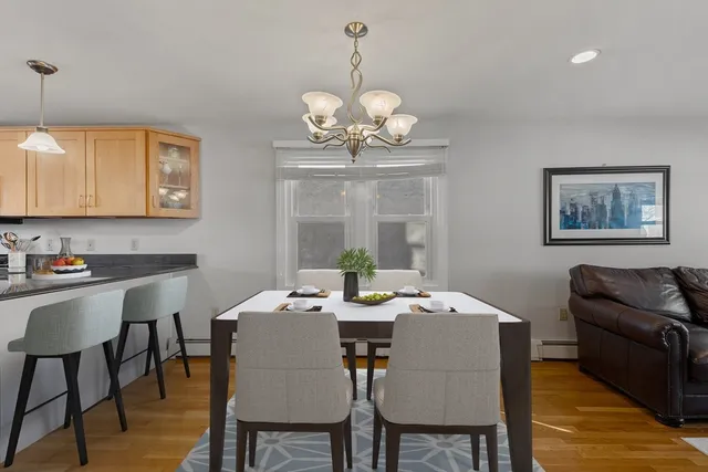a view of a dining room with furniture a chandelier and wooden floor